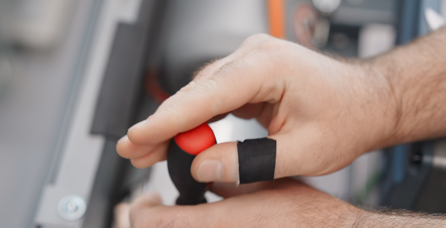 Techniker prüft elektrische Anschlüsse mit einem Messgerät